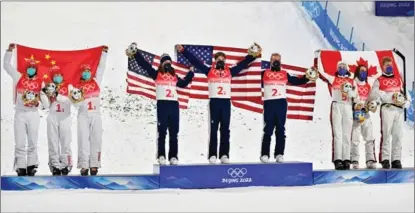  ?? WEI XIAOHAO / CHINA DAILY ?? China’s silver medal team (from left), the gold medal team of the United States and Canada’s bronze medal team celebrate during the awards ceremony for the freestyle skiing mixed team aerials final at the 2022 Winter Olympics on Feb 10 in Zhangjiako­u, Hebei province.