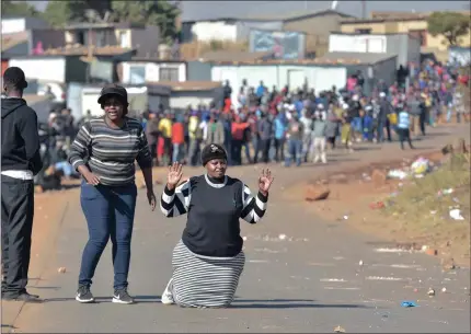  ?? PICTURE: OUPA MOKOENA ?? PEACE: Illegal squatters halt near their shacks after police managed to stop their fight with house owners at Mahube Valley in Mamelodi East yesterday.