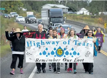  ?? DARRYL DYCK/THE CANADIAN PRESS ?? A group of family members and advocates of missing and murdered Indigenous women and girls walk along the socalled Highway of Tears, in Moricetown, B.C., on Monday.