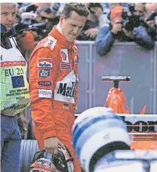  ?? FOTO: PRIVAT ?? Skeptische Blicke auf den untersucht­en Formel-1-Boliden: Michael Schumacher und Rudi Bollig.