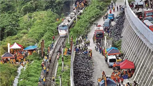  ?? AFP PIC ?? Rescue workers at the site where the train derailed inside a tunnel in the mountains of Hualien, eastern Taiwan, yesterday.