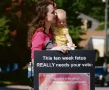  ?? JAMES SWIFT/AP ?? A woman with a child protested in favor of banning all abortions at a rally in Georgia.