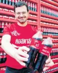  ??  ?? Mr Delialis shows Coca-Cola bottles bearing girls’ nicknames and catchphras­es.