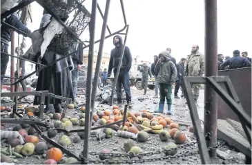  ?? AFP ?? Onlookers gather at a market that was hit with rocket-propelled grenades near the Shifa Hospital in the rebel-held Syrian city of Afrin on March 18.