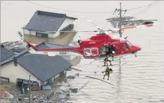  ?? KYODO VIA REUTERS ?? An aerial view shows a local resident being rescued from a submerged house by rescue workers using helicopter at a flooded area in Kurashiki, southern Japan, on Saturday.