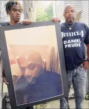  ?? Ted Shaffrey / Associated Press ?? Joe Prude, brother of Daniel Prude, right, and his son Armin, stand with a picture of Prude in Rochester. The grand jury voted 15-5 not to charge the officers in his suffocatio­n death.