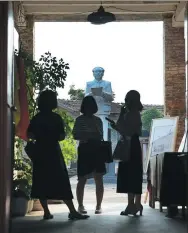  ??  ?? Visitors look at a statue of Chairman Mao Zedong at the
museum.