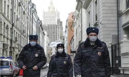  ??  ?? Russian police officers patrol an almost empty Arbat street in Moscow on Thursday. Photograph: Kirill Zykov/AP