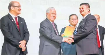  ??  ?? Manyin (second left) presenting the award to Chang Sam Foh of SJK Chung Hua Serian while Martin (third left) and Yunus (left) look on. — Photo by Kong Jun Liung