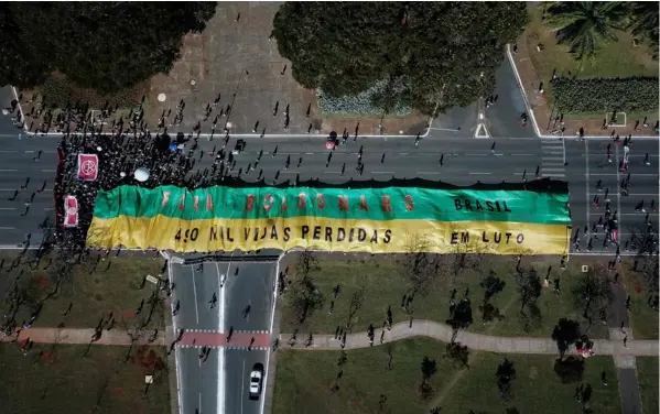  ?? AFP ?? Vista aérea de una protesta realizada ayer, en Brasilia, por partidos de oposición y movimiento­s sociales contra el manejo del presidente brasileño Jair Bolsonaro de la pandemia de covid-19. El jerarca insiste en minimizar las consecuenc­ias y efectos del virus.