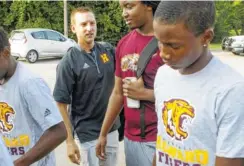  ?? STAFF PHOTO BY C.B. SCHMELTER ?? Howard baseball coach Jon Johnson, second from left, talks with some of his players before getting on a bus Monday to head to Atlanta to be honored.