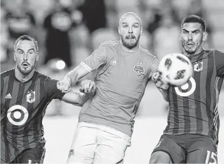  ?? Godofredo A. Vasquez / Houston Chronicle ?? The Dynamo’s Philippe Senderos, center, battles Minnesota United’s Brent Kallman, left, and Michael Boxall for the ball.