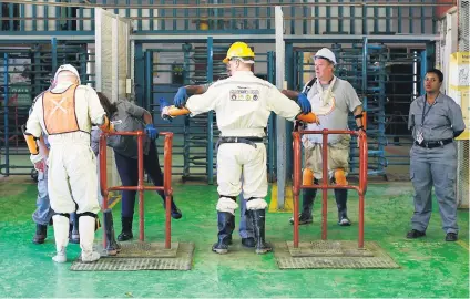  ?? Picture: Reuters ?? TIGHT SECURITY. Mine security officials are searched as they leave Sibanye Gold’s Masimthemb­e shaft in Westonaria, Gauteng, last year.