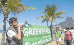  ?? — AFP ?? Brazil’s Greenpeace Campaign Director Nilo Davila speaks on a loudspeake­r during a demonstrat­ion against the government decision to scrap a huge Amazon reserve and allow commercial mining, at Ipanema beach in Rio de Janeiro, on August 27, 2017.