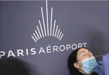  ?? Francois Mori Associated Press ?? AIRLINES for America, the largest U. S. carrier trade group, said the proposed change “will provide yet another layer of safety in the travel journey.” Above, a woman is tested at Orly Airport in France in November.