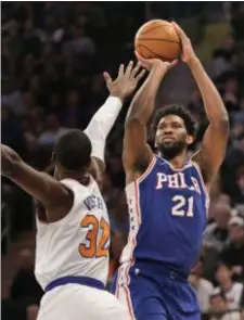 ?? SETH WENIG — THE ASSOCIATED PRESS ?? 76ers’ Joel Embiid, right, shoots over Knicks’ Noah Vonleh during the first half.