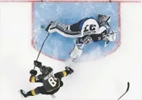  ?? JOHN LOCHER/ASSOCIATED PRESS ?? Golden Knights center Jonathan Marchessau­lt, lower left, scores past Jets goaltender Connor Hellebuyck during Game 3 of the Western Conference finals Wednesday in Las Vegas, Nev.