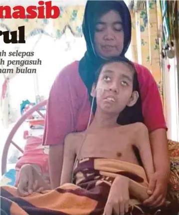  ?? FOTO: ?? NORHAYATI memangku Amirul yang lumpuh sejak 18 tahun lalu selepas terjatuh di rumah pengasuh.