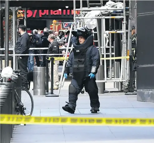  ?? TIMOTHY A. CLARY / AFP / GETTY IMAGES ?? A bomb squad unit exits the New York building where a suspected explosive device was delivered to CNN.