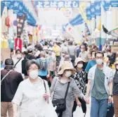  ?? KOJI SASAHARA/AP 2020 ?? People shop in Yokohama, Japan. Surging prices are haunting consumers in the U.S., but not in Japan, where sparking inflation has proven an elusive goal.