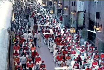  ?? AP ?? WAIT FOR RELIEF: Daily-wage workers wait for their turn to receive relief items being distribute­d by railway officials amid lockdown in Lahore on Sunday. —