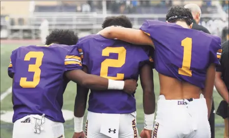  ?? Tyler Sizemore / Hearst Connecticu­t Media ?? Westhill players Nasir Thornton (3), David Moodie (2) and Kevin Leba (1) lean on one another during a moment of silence honoring teammate Jordan Martinez at Westhill High School on Monday, the team's first game since Martinez’s death.