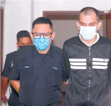  ??  ?? Satvender Singh (right) being escorted by the policeman at the Shah Alam High Court lobby yesterday. – Bernama photo