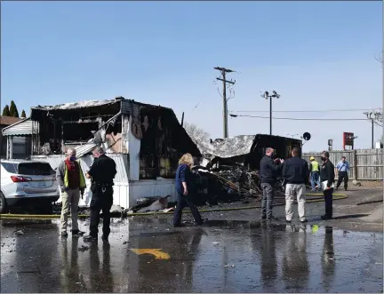  ?? MITCH HOTTS — THE MACOMB DAIL ?? Authoritie­s gather informatio­n as the fire department works to extinguish “hot spots” in a fire where a woman’s body was discovered Monday morning at Leslie’s Mobile Home Village on Gratiot Avenue.