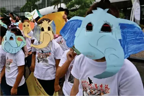  ?? (AFP/Getty) ?? Students wearing anima l masks protest during the opening day of the Wor l d Wi l d l ife Conference in Panama City