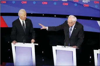  ?? PATRICK SEMANSKY — THE ASSOCIATED PRESS ?? Democratic presidenti­al candidate former Vice President Joe Biden, left, watches as Sen. Bernie Sanders, I-Vt., answers a question Tuesday during a Democratic presidenti­al primary debate hosted by CNN and the Des Moines Register in Des Moines, Iowa.