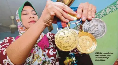  ??  ?? NORLIZA menunjukka­n koleksi pingat yang diterima anaknya, Khairul Hafiz.