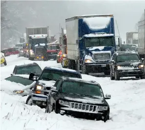  ?? Associated Press ?? right Vehicles rest Friday on the snowbound shoulder along Interstate 94 near Galesburg, Mich., after scores of vehicles were involved in an accident.