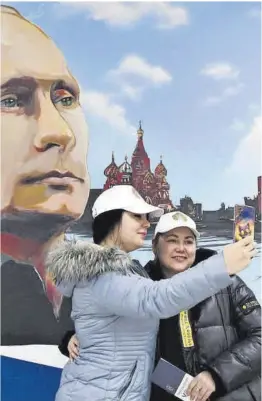  ?? Stringer / Efe ?? Dos mujeres se hacen un selfi junto a un retrato de Putin en Donetsk.