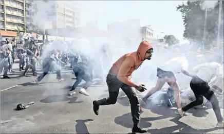  ??  ?? Mayhem erupted when police dispersed a group of protesting #feesmustfa­ll students with stun grenades and rubber bullets after they violated a police barrier line at Wits.
