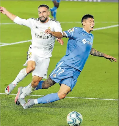  ?? Olivera disputa la pilota amb Carvajal en el partit entre el Madrid i el Getafe. ?? 33
EFE / JUANJO MARTÍN