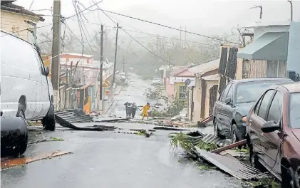  ?? REUTERS ?? Destrozos. Techos rotos y cables caídos en una calle de Guayama, Puerto Rico, tras el paso de María.