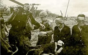  ??  ?? Captured Viet Cong fighters awaiting an uncertain fate having been offloaded from a Huey helicopter straight from a battle zone near Pleiku.