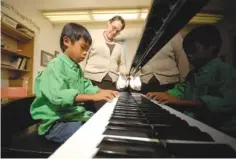  ?? STAFF PHOTO BY TIM BARBER ?? Piano teacher Andrea Exum works with Ethan Farnum, 8, during a piano lesson Oct. 13, 2010, at Cadek Hall.