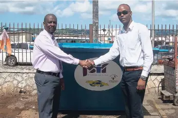  ??  ?? Councillor Mitchell (left) hands over a skip to Edward Muir, regional operations manager of SPM.