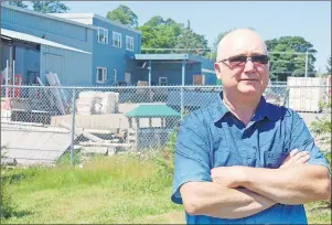  ?? JIM DAY/THE GUARDIAN ?? Charlottet­own resident Vaughan Davies stands in front of property zoned industrial that he considers an eyesore and the source of plenty of dust that blows on to his property.