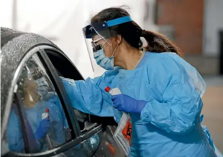  ?? AP ?? A nurse takes a swab from a driver at a drive-through coronaviru­s testing station set up by the University of Washington Medical Centre in Seattle. US President Donald Trump has announced new measures to deal with the outbreak, including funding for more drive-through testing centres.