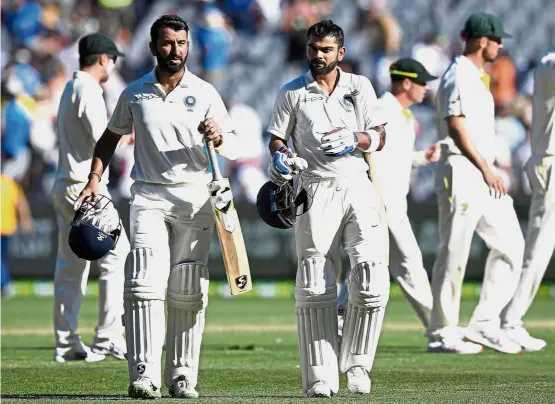  ?? — AP ?? Star batsmen: India’s India’s Cheteshwar Pujara (left) and Virat Kohli leave the field after play on day one of the third cricket Test between India and Australia in Melbourne, Australia, yesterday.