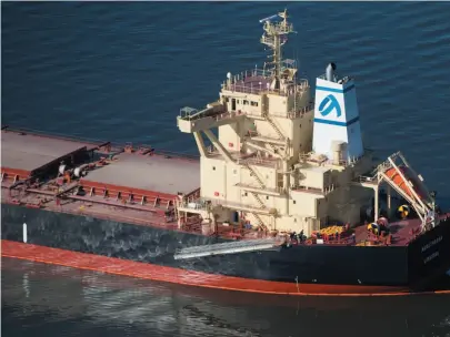  ?? CP PHOTO ?? A spill response boat monitors a boom placed around the bulk carrier cargo ship Marathassa after an oil spill on Burrard Inlet in Vancouver on Thursday.