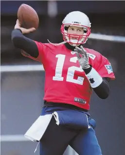  ?? STAFF PHOTO BY JOHN WILCOX ?? THROWING SOME SHADE: Tom Brady warms up before practice yesterday at Gillette Stadium, where he also took exception to questions about his relationsh­ip with coach Bill Belichick.