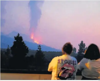  ?? EP ?? Dos personas observan una de las bocas eruptivas del volcán de Cumbre Vieja.