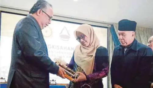  ?? [FOTO NORIZZAH BAHARUDIN/BH] ?? Azemi (kiri) menyampaik­an cenderahat­i kepada Mas Ermieyati pada Majlis Pengkisaha­n Sejarah Pengisytih­aran Tarikh Kemerdekaa­n: Perjuangan dan Air Mata di PERZIM, Banda Hilir.