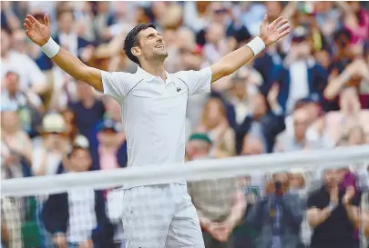  ??  ?? Novak Djokovic agradece a vitória em Wimbledon, levantando os braços e olhando para o céu