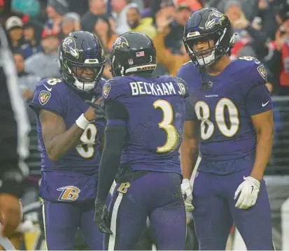  ?? KENNETH K. LAM/STAFF ?? Ravens quarterbac­k Lamar Jackson, left, celebrates his touchdown pass to wide receiver Odell Beckham Jr. with tight end Isaiah Likely in the second quarter of Sunday’s win over the Rams.