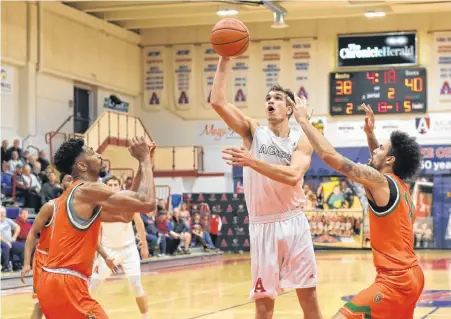  ??  ?? Forest Mahoney goes to the hoop for the Acadia Axemen.