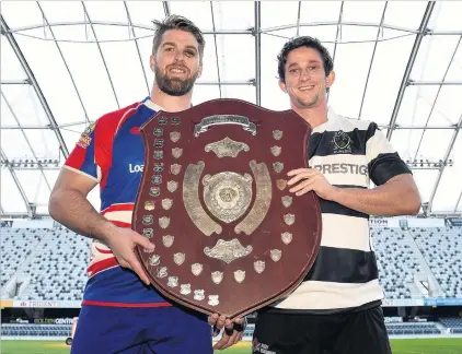  ?? PHOTO: PETER MCINTOSH ?? Let the armwrestle begin . . . Harbour captain Charles Elton (left) and Southern captain Josh Walden get an early touch of the premier shield, which is at stake in the club final at Forsyth Barr Stadium this afternoon.